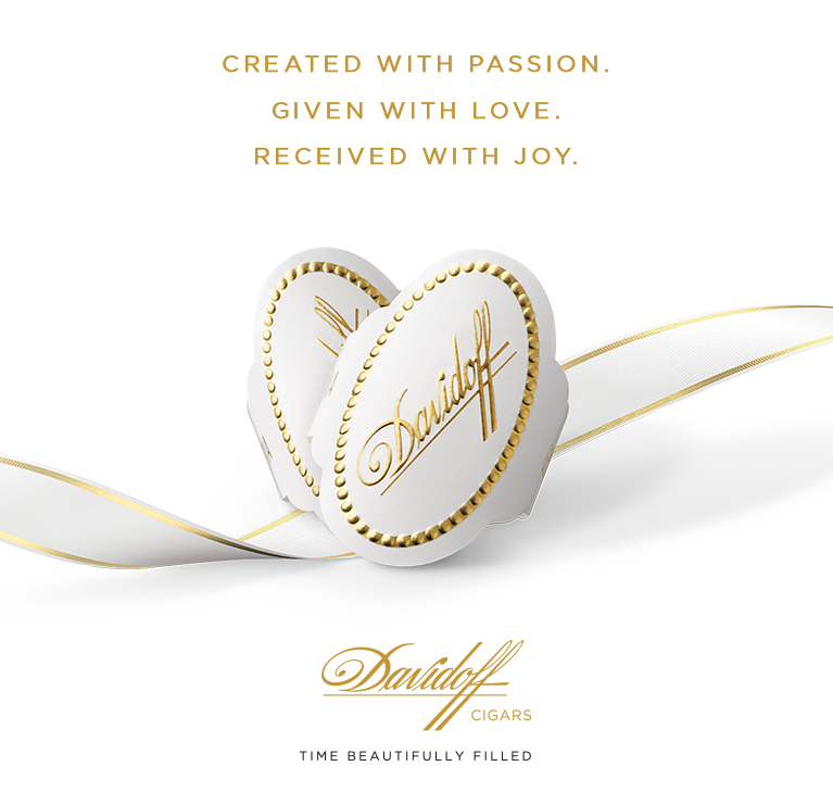Davidoff White Band cigar rings placed in heart-shape on a white/golden ribbon. Text: Created with passion. Given with love. Received with joy.