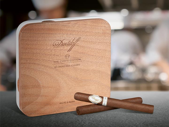 Two Davidoff Chefs Edition 2021 Cigars next to its box-packaging made of wooden lid and ceramic base