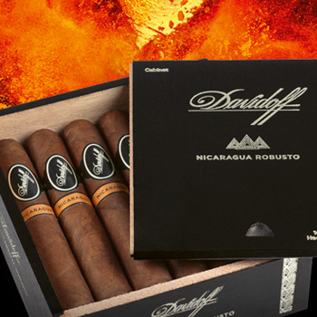 Davidoff Nicaragua Zigarren in ihrer Kiste mit geöffnetem Deckel. Feuer im Hintergrund.